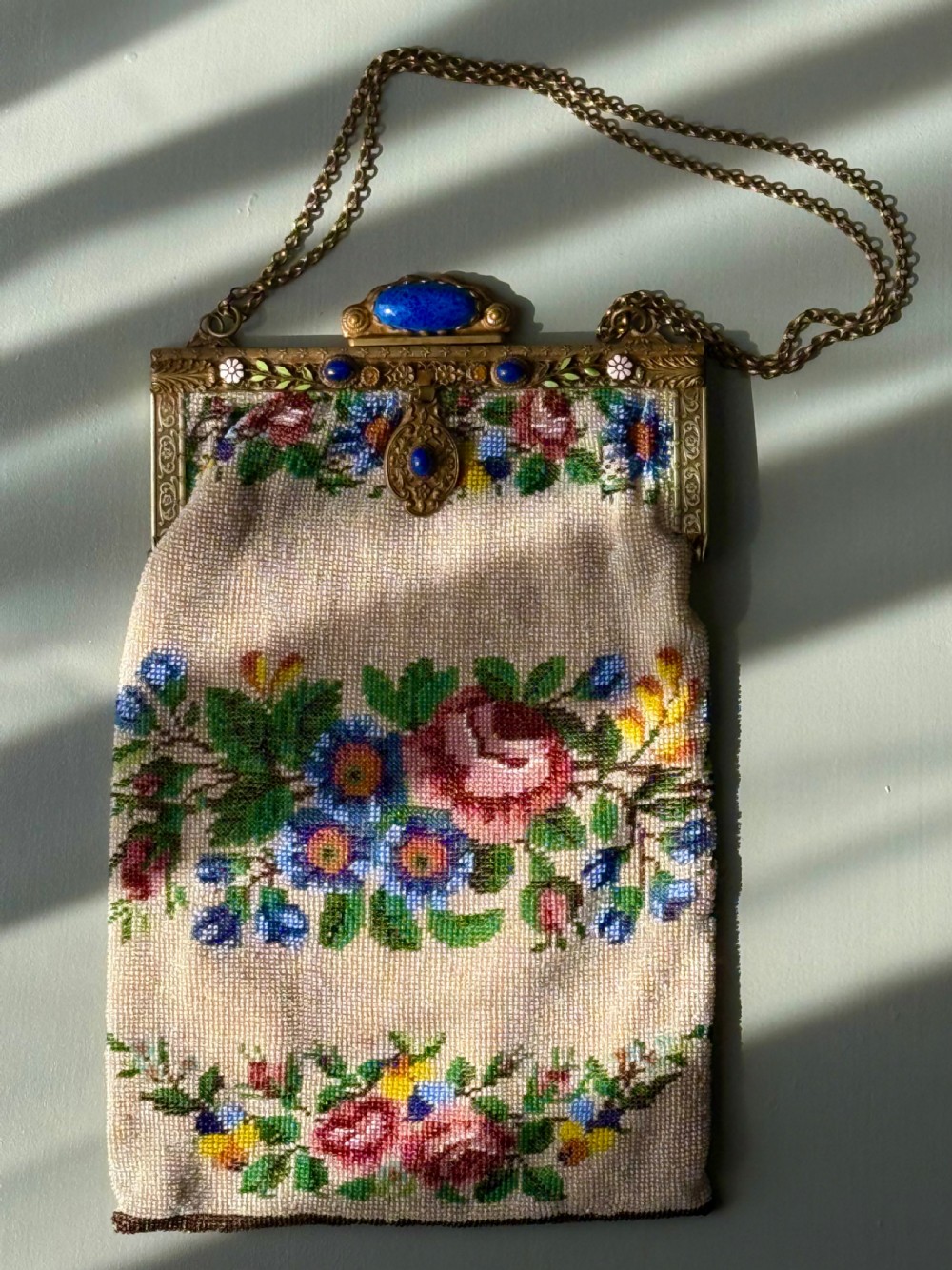 A collection of seven 1920s evening bags featuring micro-beaded floral patterns, silver mesh, and decorative metal frames arranged on a flat surface. View VIII