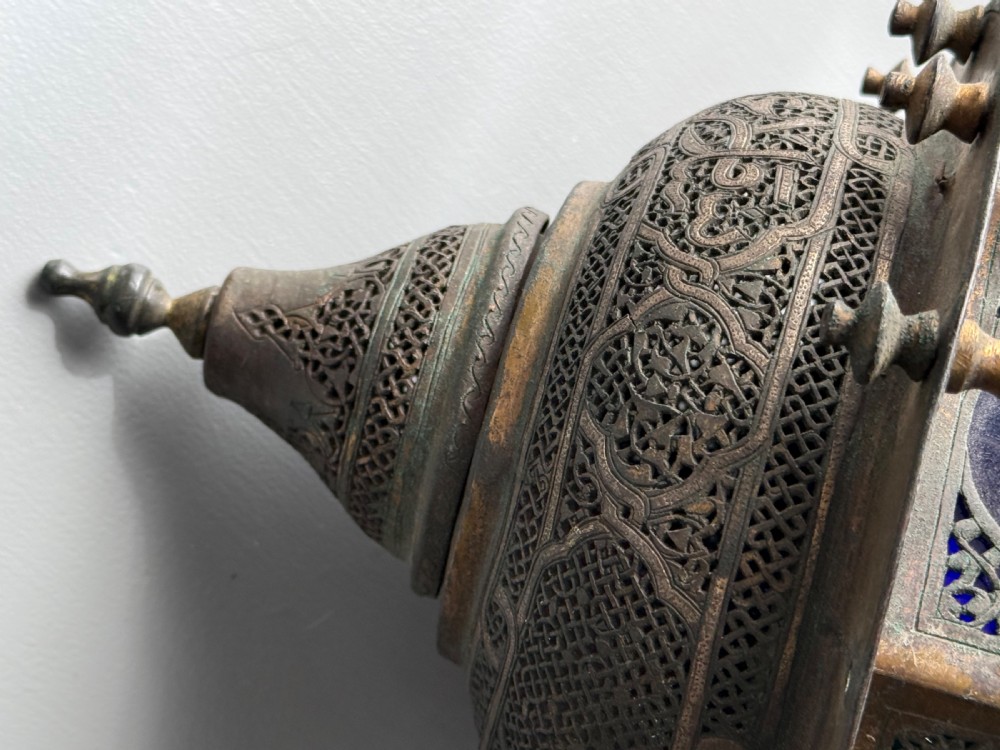 A 19th-century Moorish style pierced brass hanging lantern with a central blue glass panel section and a finial top. View IV