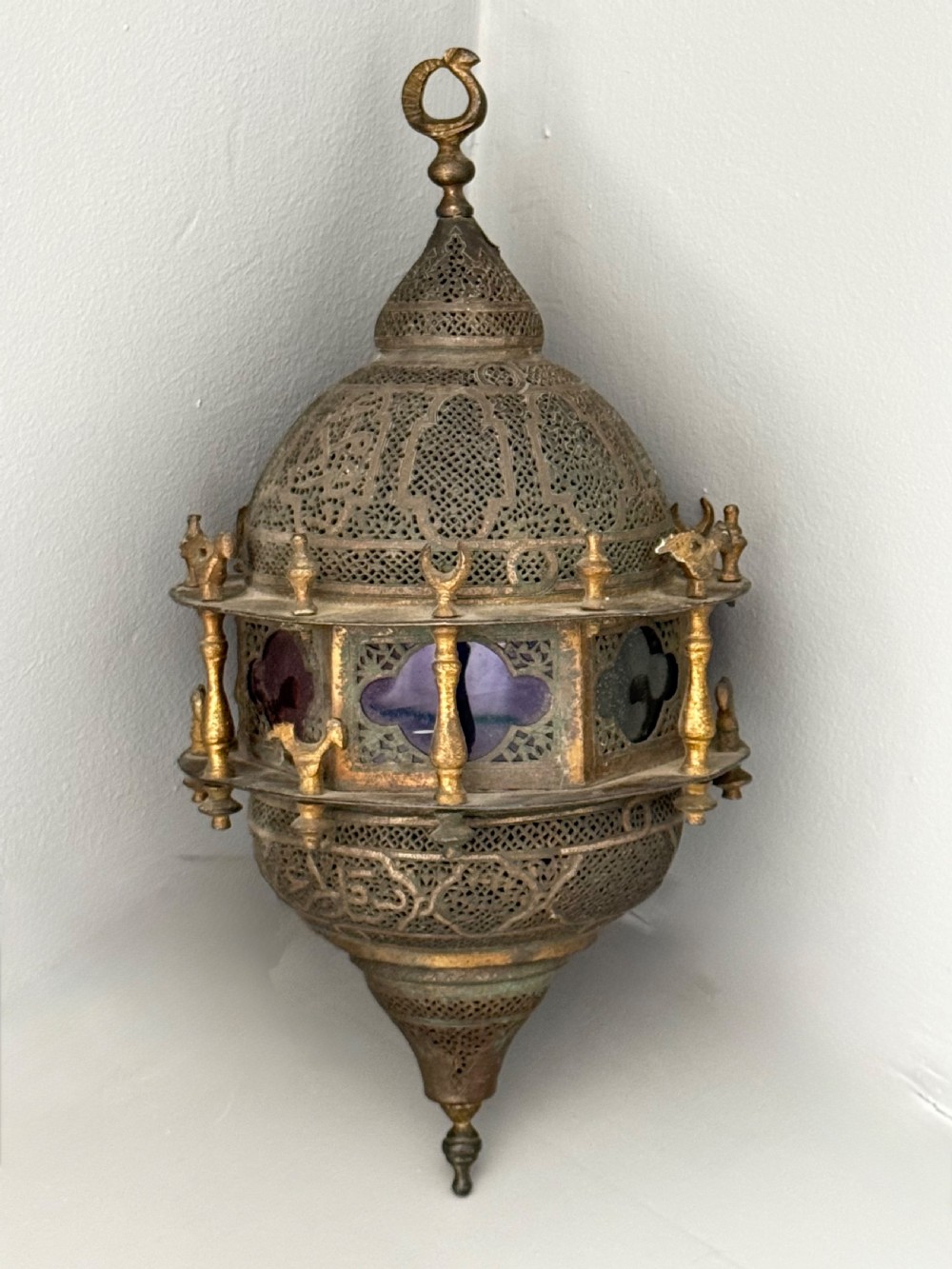 A 19th-century Moorish style pierced brass hanging lantern with a central blue glass panel section and a finial top. View V