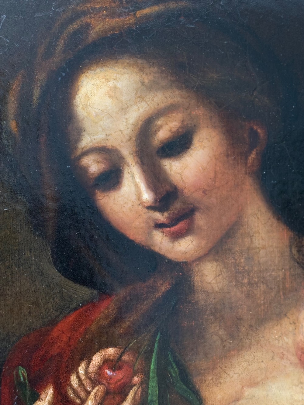 An early 18th-century Italian Baroque oil painting on canvas depicting the Madonna holding the infant Christ Child while holding cherries. View II