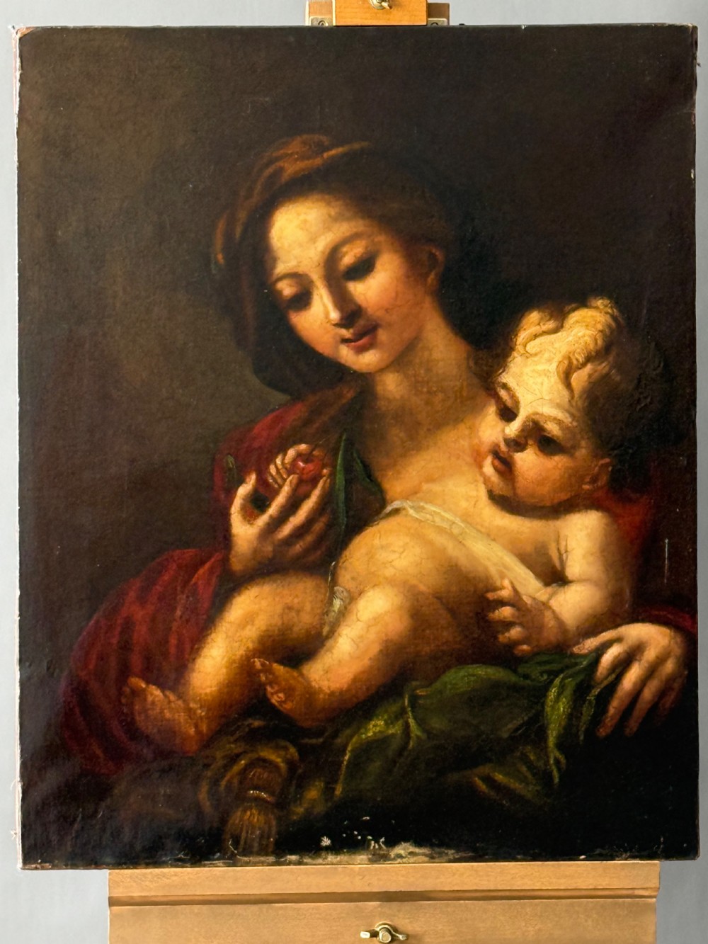 An early 18th-century Italian Baroque oil painting on canvas depicting the Madonna holding the infant Christ Child while holding cherries. View IV