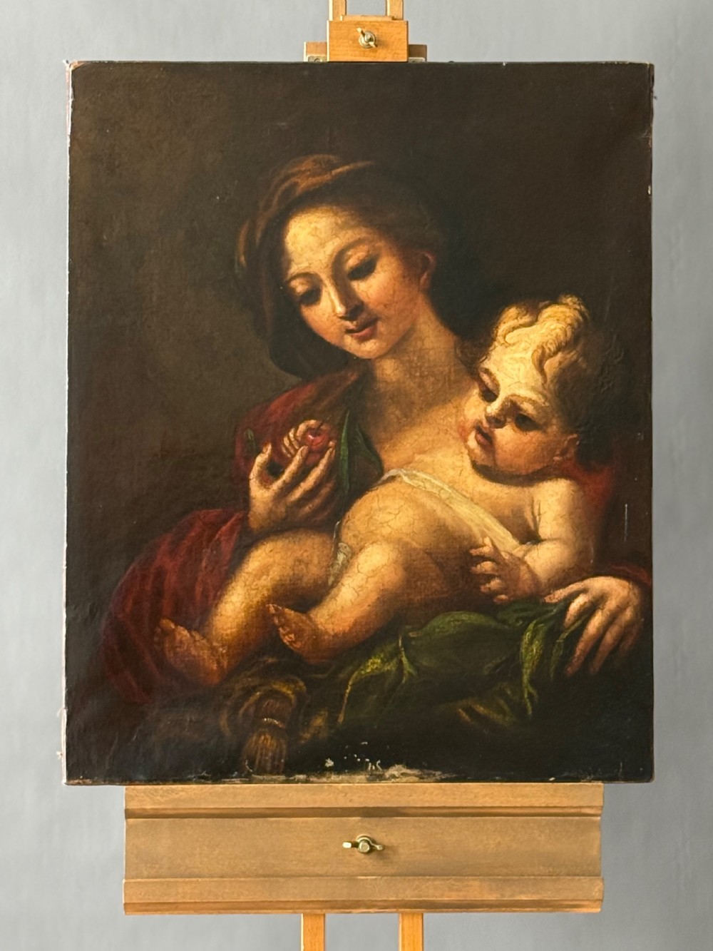 An early 18th-century Italian Baroque oil painting on canvas depicting the Madonna holding the infant Christ Child while holding cherries. View V