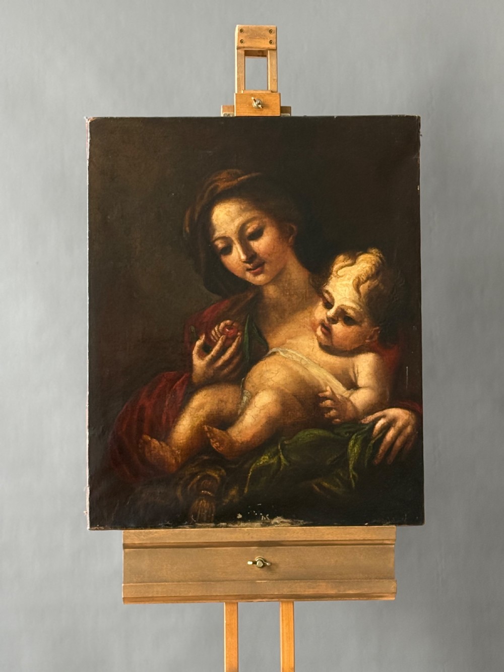 An early 18th-century Italian Baroque oil painting on canvas depicting the Madonna holding the infant Christ Child while holding cherries. View VI