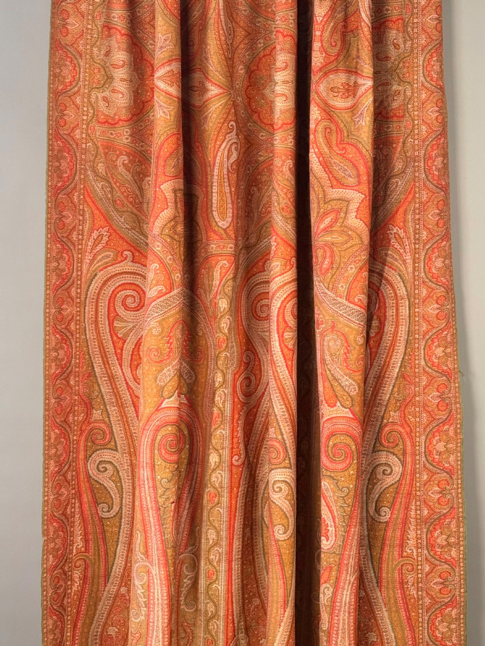A large Victorian woven wool shawl featuring dense teardrop Paisley patterns in shades of terracotta, ochre, and green with a fringed border. View IV