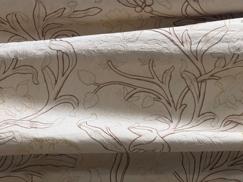 A cream-coloured Art Nouveau silk coverlet featuring hand-embroidered botanical motifs with a quilted border and pointed lace trim. View IV