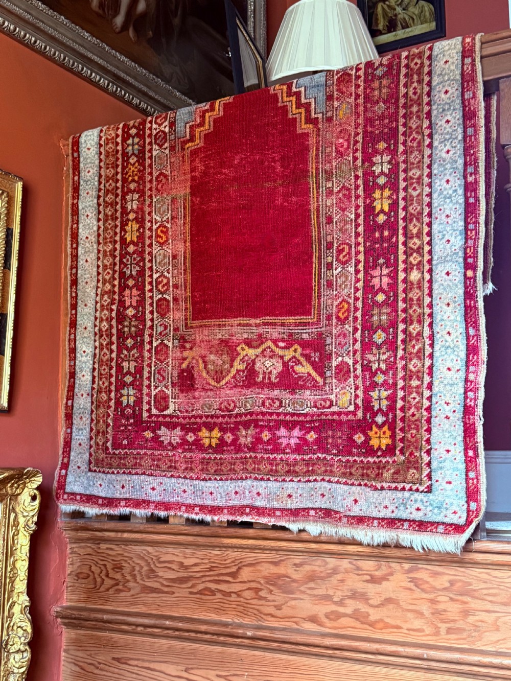 A late 19th-century Anatolian hand-knotted wool prayer rug featuring a central crimson mihrab niche motif surrounded by geometric borders in light blue, cream, and red. View III