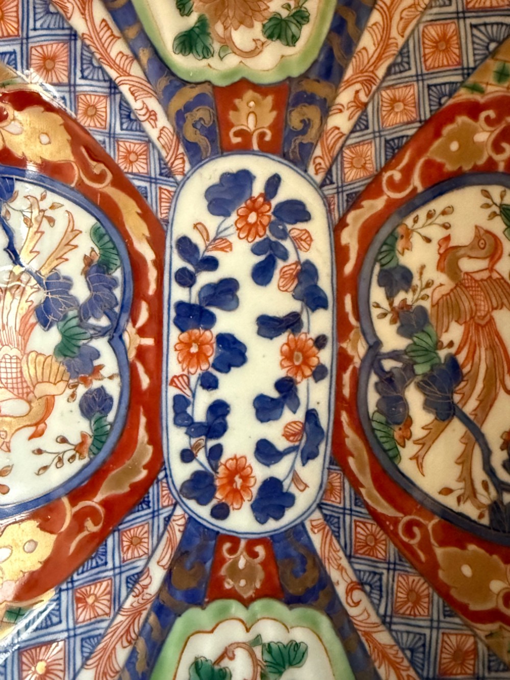An oblong 19th-century Japanese Imari porcelain dish with scalloped edges, decorated with hand-painted cobalt blue, orange, green, and gold floral and bird patterns. View IV