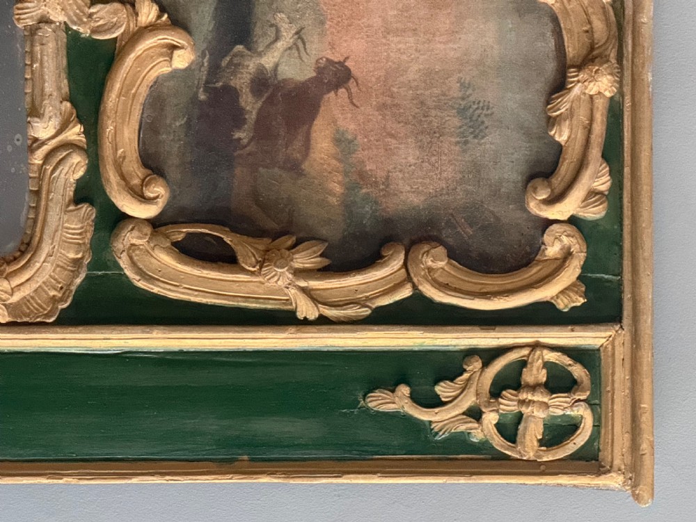 An eighteenth-century style French Rococo trumeau mirror featuring a painted green timber frame with carved gilded scrollwork surrounding an upper landscape painting and a lower rectangular mirror plate. View V