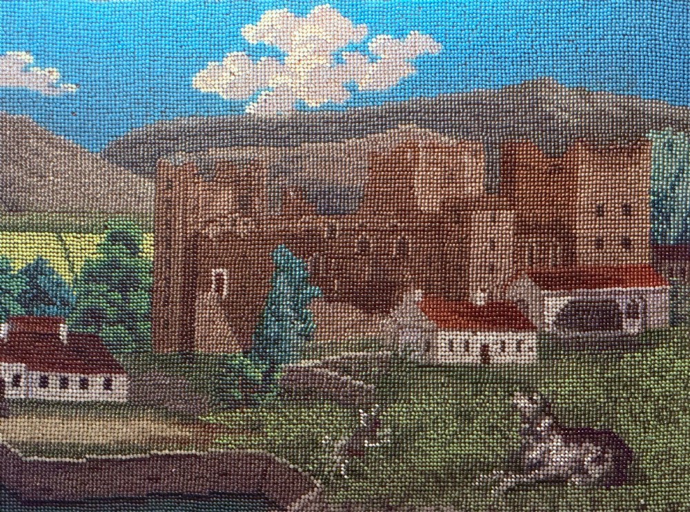 A framed 19th-century beadwork picture depicting Bolton Castle in Yorkshire with embroidered text and dates inside a gilded wooden frame. View III