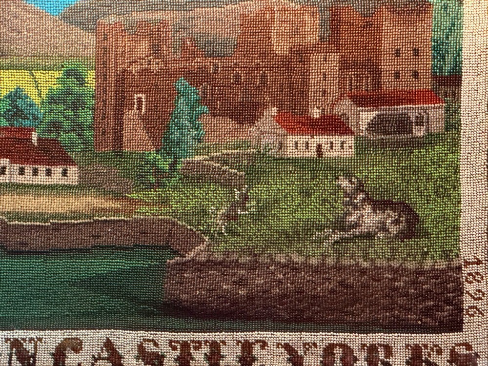A framed 19th-century beadwork picture depicting Bolton Castle in Yorkshire with embroidered text and dates inside a gilded wooden frame. View IV