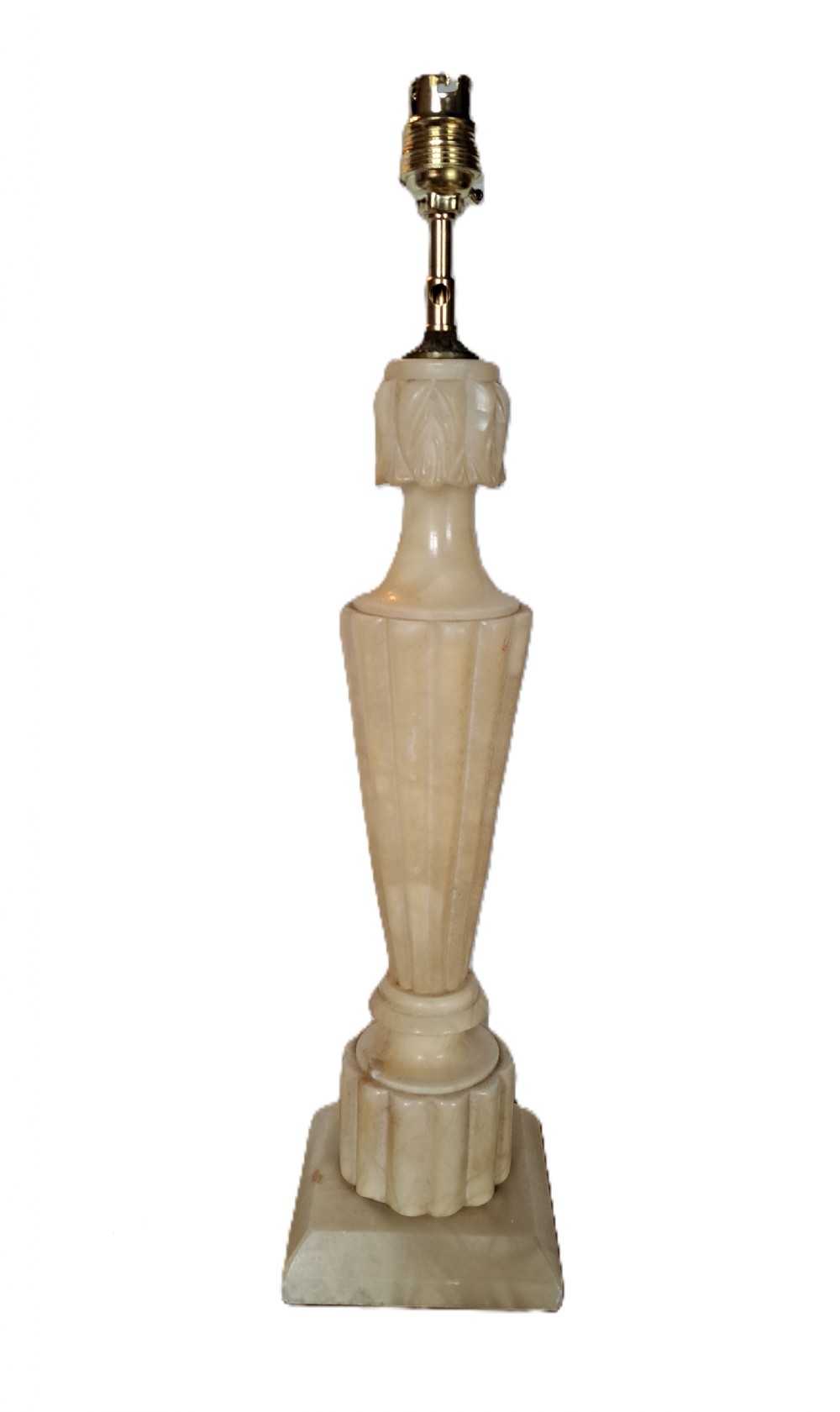 A tall carved cream alabaster table lamp base featuring a square pedestal, a fluted tapered body, carved leaf detailing, and a brass bulb socket.