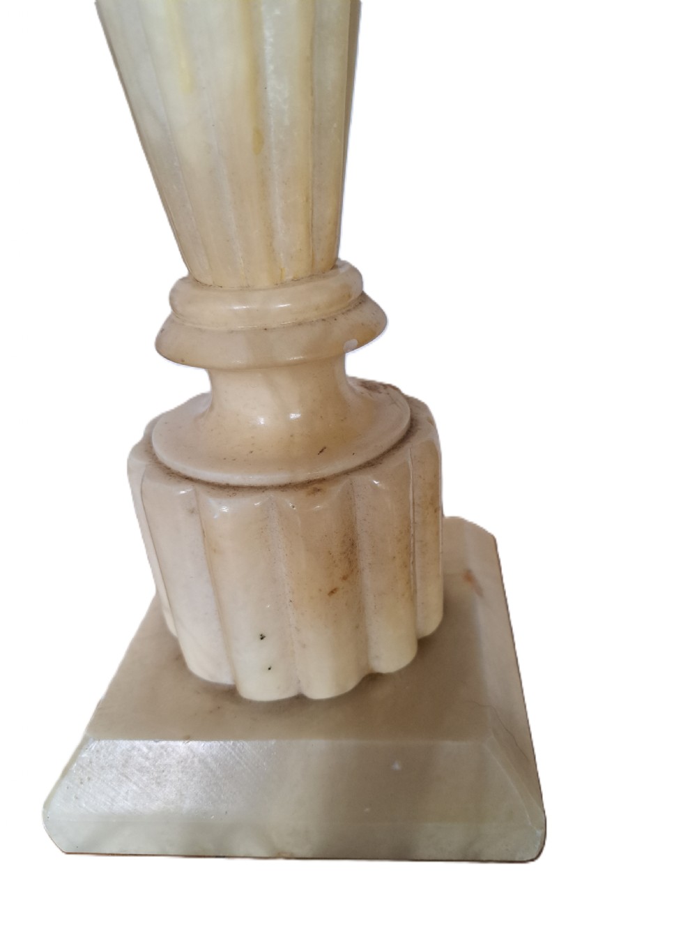 A tall carved cream alabaster table lamp base featuring a square pedestal, a fluted tapered body, carved leaf detailing, and a brass bulb socket. View IV