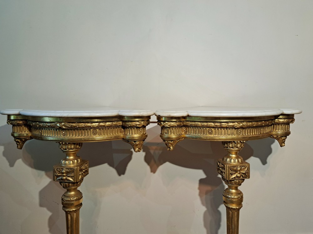 A pair of nineteenth-century French Neoclassical giltwood corner console tables with white marble tops and fluted single legs. View IV