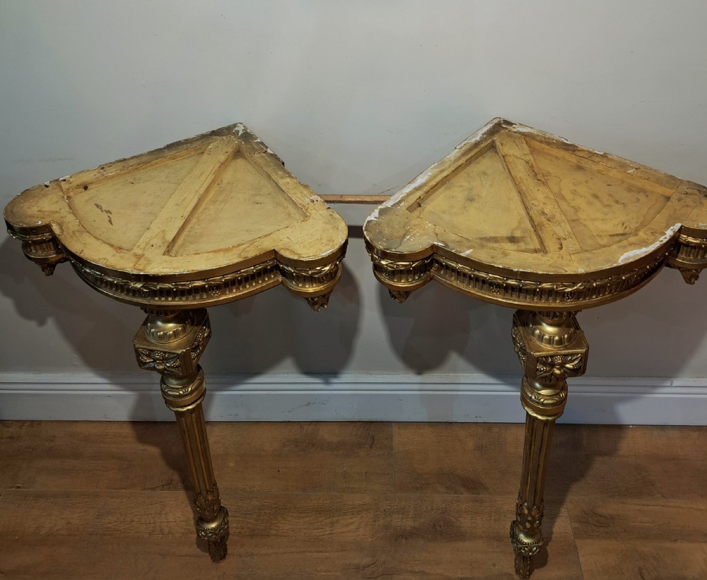 A pair of nineteenth-century French Neoclassical giltwood corner console tables with white marble tops and fluted single legs. View VII