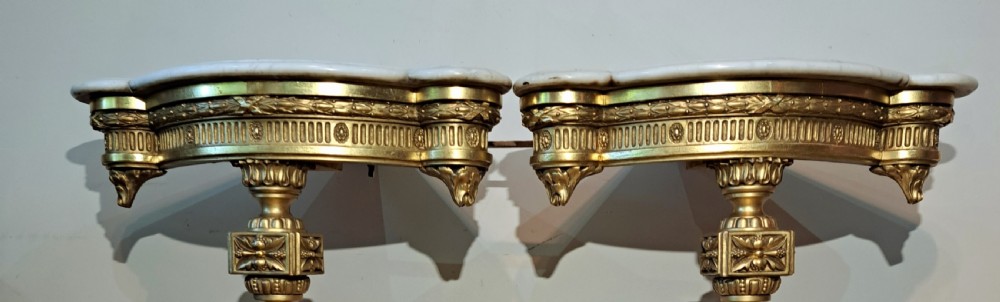 A pair of nineteenth-century French Neoclassical giltwood corner console tables with white marble tops and fluted single legs. View VIII
