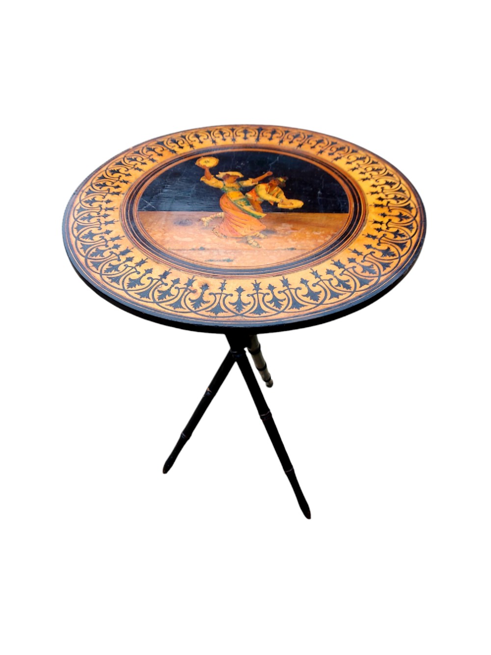A 19th-century circular Sorrento side table with detailed marquetry depicting dancing figures framed by a foliate border, set upon ebonised tripod legs.