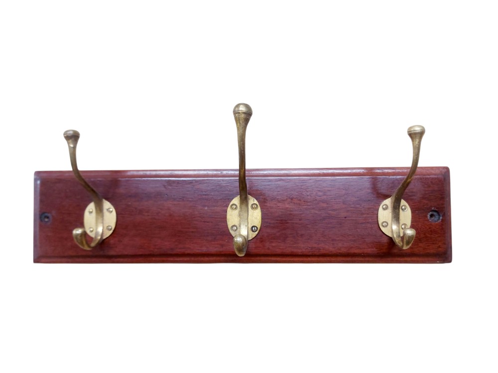 A rectangular polished mahogany board featuring three mounted cast brass double coat and hat hooks.
