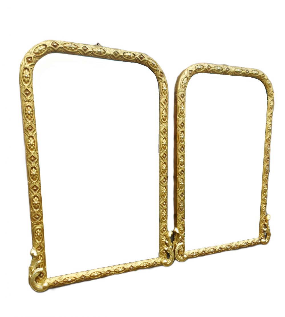 A matching pair of arched nineteenth-century giltwood frames featuring relief geometric patterns and carved acanthus corner accents.