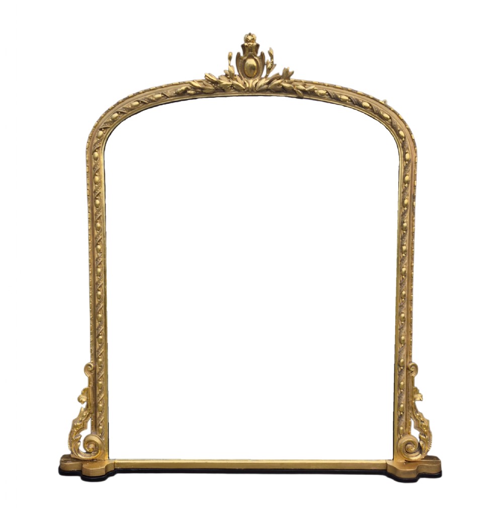 A large arched 19th-century gold giltwood overmantel mirror featuring a top foliage crest, beaded inner moulding, and scrolled side flourishes.