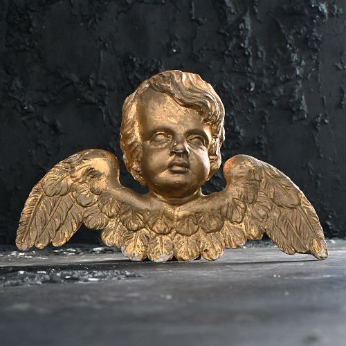 fig 1. A 19th-century carved wood cherub head with outstretched feathered wings finished in aged gold gilding.