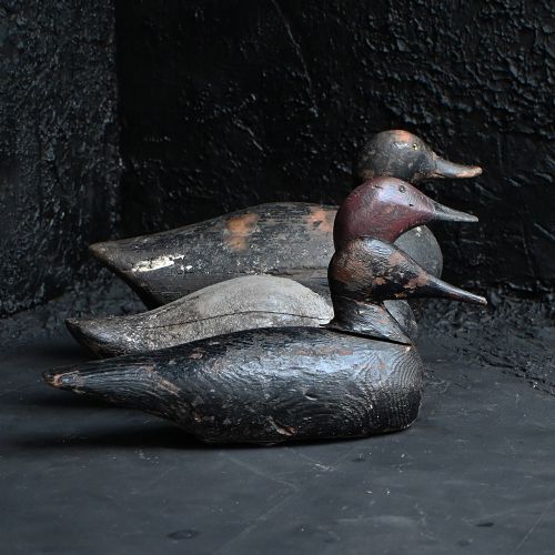 fig 1. A hand-carved wooden duck decoy featuring a distressed black paint finish and an elongated beak.