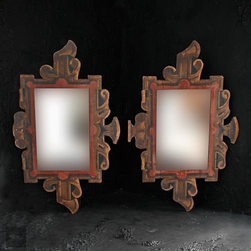 fig 1. A pair of early twentieth-century fairground mirrors with carved scrollwork borders painted in gold and red tones around central rectangular mirror panels.