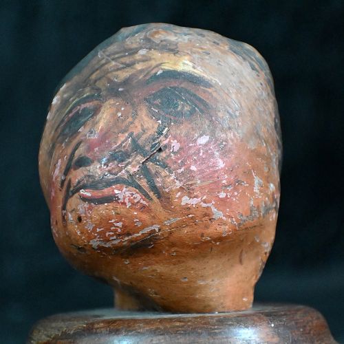 fig 1. A pair of 19th-century folk art carved heads with painted facial features mounted on circular turned wooden bases.