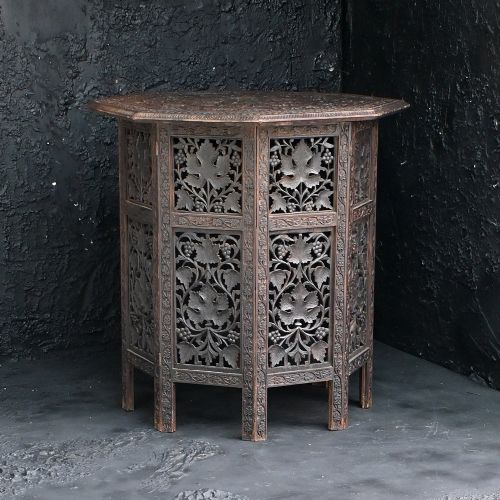 fig 1. An octagonal 19th-century Anglo-Indian side table featuring detailed pierced vine and leaf carvings on a dark wood folding base.