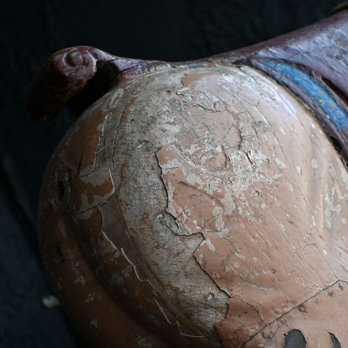 fig 3. A pair of 19th-century carved wooden carousel pigs with distressed pink paint mounted on slender iron display stands.