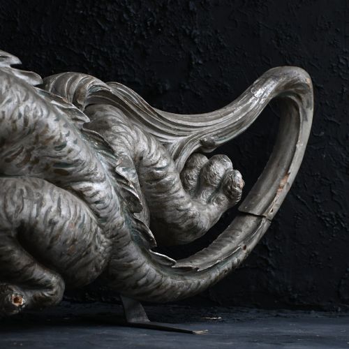 fig 1. An early twentieth-century hand-carved wooden fairground ride fragment depicting an elongated silver dragon with open jaws and detailed scale carving.