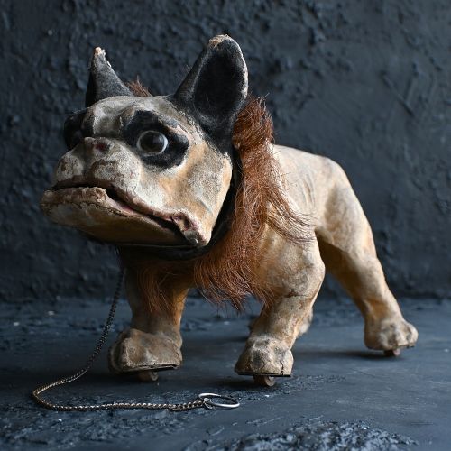 fig 6. A nineteenth-century papier-mache French bulldog automaton toy with glass eyes, a fur collar, and small wheels under its paws.