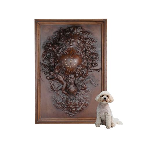 fig 12. A rectangular dark wood carved panel featuring a central heart-shaped clock face surrounded by allegorical figures, a sun motif, and clouds within a moulded wooden frame.