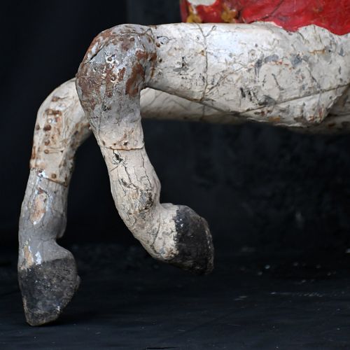 fig 4. A 19th-century French carved wooden carousel horse with distressed white, red, green, and blue paint in a galloping pose.