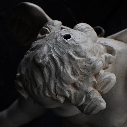 fig 4. A late 18th-century hand-carved wooden cherub figure with outstretched arms, detailed wings, and a painted grey finish.