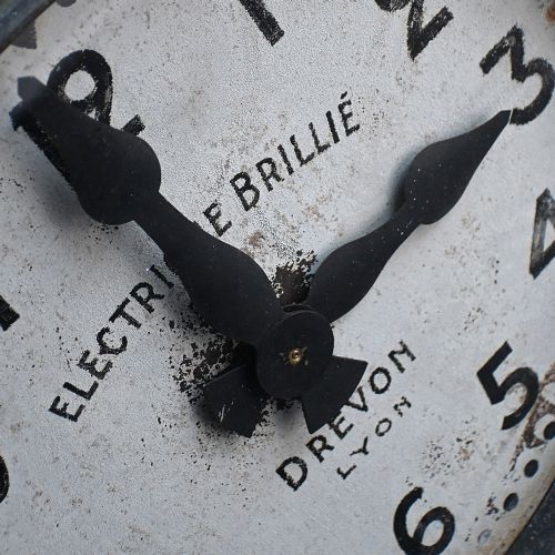 fig 2. An oversized circular French station wall clock featuring a dark grey metal bezel, off-white dial with Arabic numerals, and French maker inscriptions.