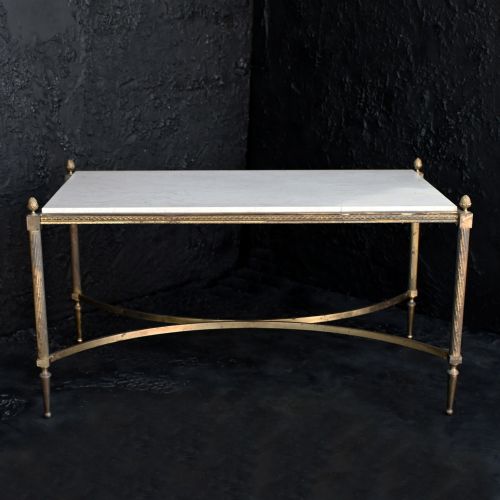 fig 4. A rectangular Neoclassical style coffee table featuring a cream marble surface, a gilt brass frame with fluted legs, corner pineapple finials, and a curved stretcher.