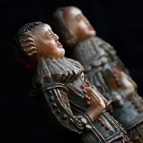 fig 4. A pair of hand-carved polychrome wax figures depicting a man and a woman in 17th-century attire with hands clasped in prayer.