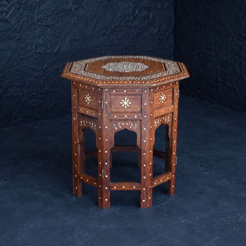fig 1. An early 20th-century octagonal wooden occasional table featuring intricate bone inlay floral and geometric patterns across the top and arched apron base.