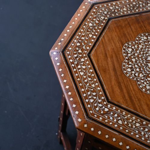 fig 6. An early 20th-century octagonal wooden occasional table featuring intricate bone inlay floral and geometric patterns across the top and arched apron base.