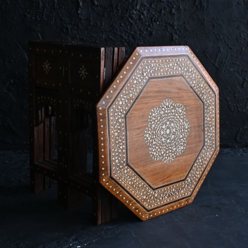 fig 7. An early 20th-century octagonal wooden occasional table featuring intricate bone inlay floral and geometric patterns across the top and arched apron base.