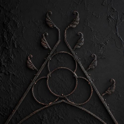 fig 1. A Victorian Gothic Revival pointed archway made from dark wrought iron featuring leaf crockets and circular tracery.