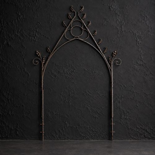 fig 2. A Victorian Gothic Revival pointed archway made from dark wrought iron featuring leaf crockets and circular tracery.