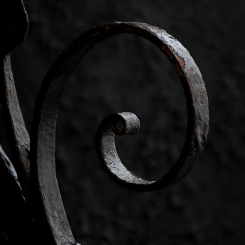 fig 4. A Victorian Gothic Revival pointed archway made from dark wrought iron featuring leaf crockets and circular tracery.