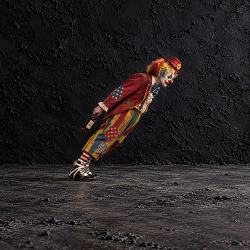 fig 3. A pair of early 20th-century black and white leather clown boots featuring exaggerated toe boxes, lace-up fronts, buckled straps, toe zippers, and fitted wooden boot stretchers.