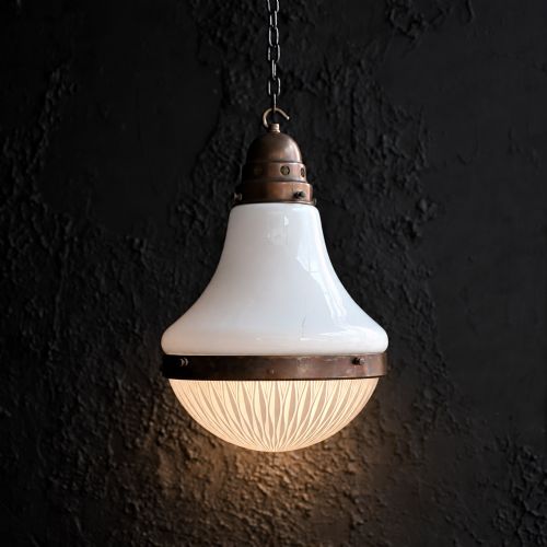 fig 1. An early 20th-century pendant light featuring a white opal glass upper shade, a patterned clear glass lower diffuser, and patinated brass fittings suspended by a chain.