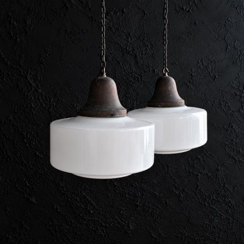 fig 3. A matched pair of Art Deco pendant lights featuring large white opal glass shades topped with bell-shaped copper galleries and hanging chains.