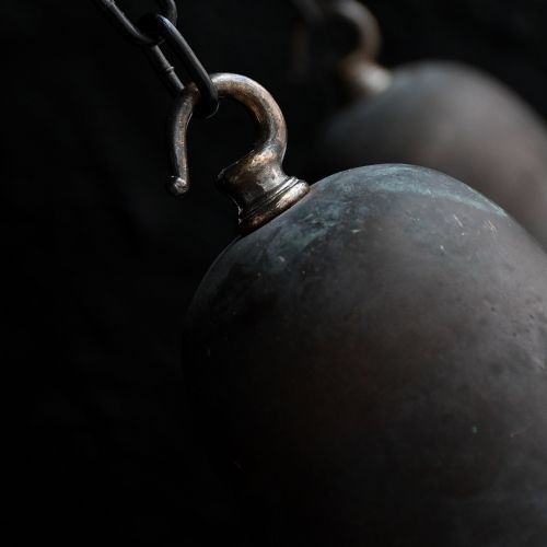 fig 6. A matched pair of Art Deco pendant lights featuring large white opal glass shades topped with bell-shaped copper galleries and hanging chains.