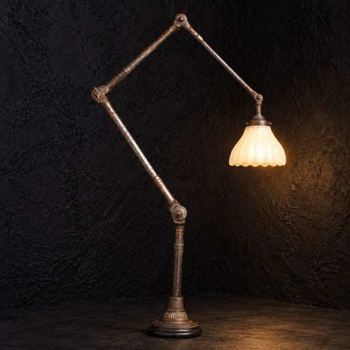 fig 2. An early 20th-century four-arm articulated brass floor lamp with a white frilled glass shade on a heavy circular base.
