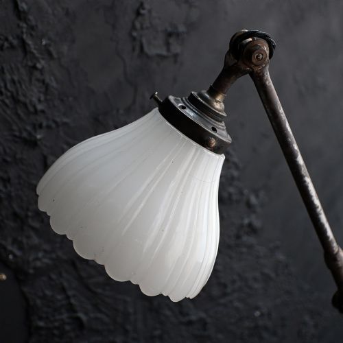 fig 7. An early 20th-century four-arm articulated brass floor lamp with a white frilled glass shade on a heavy circular base.