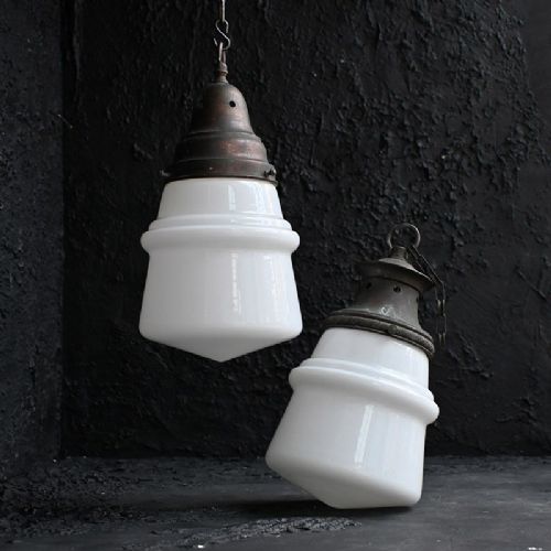 fig 2. A pair of early twentieth century opaline glass pendant lights featuring milk-white glass shades and aged brass galleries with suspension chains.